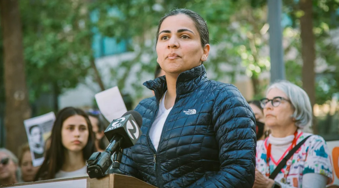 Dr. Aisha Wahab outside, at podium