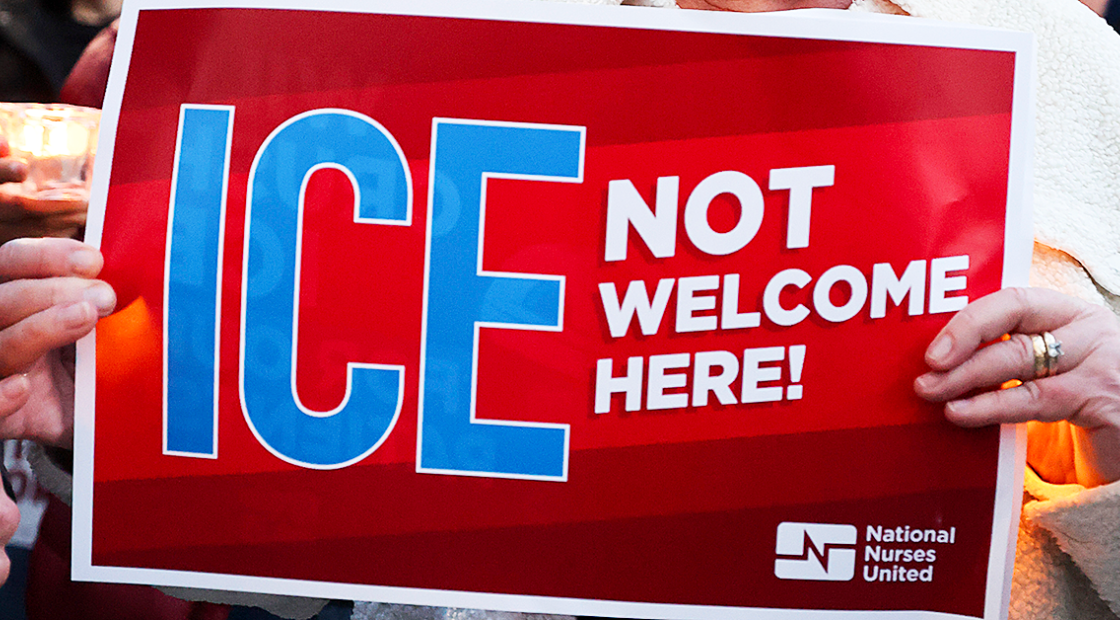 Hands holding sign "ICE NOT welcome here"
