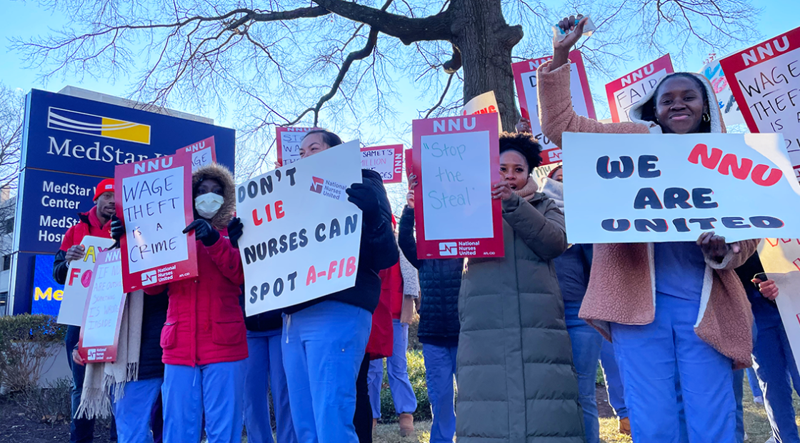 MedStar nurses in front of hospital with signs: "Wage theft is a crime" "Don't lie, nurses can spot a-fib" "Stop the steal" "We are NNU united"