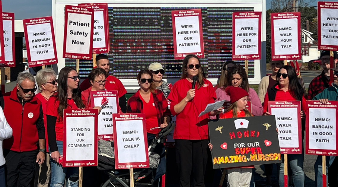 Nurses rally outside of hospital holding signs "We're here for our patients"