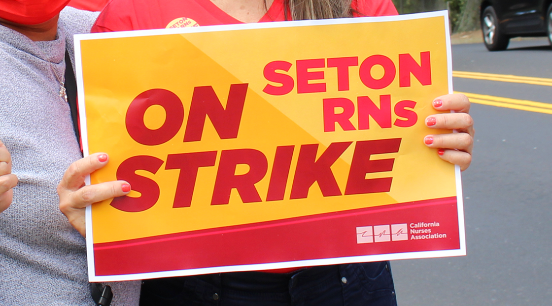 Nurse holding sign: Seton RNs on STRIKE