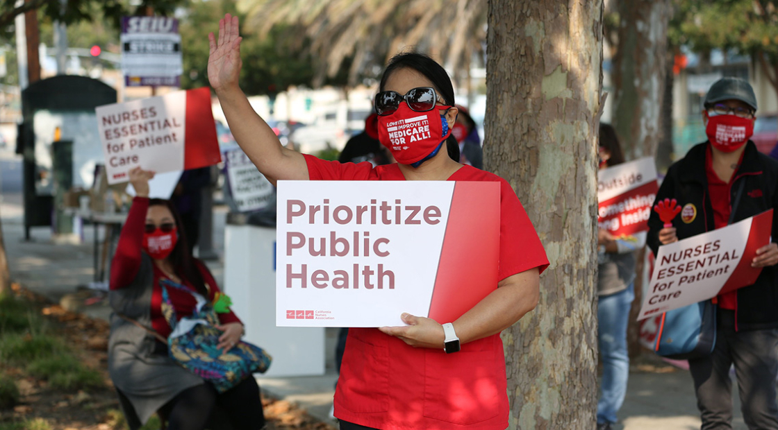 Nurse hold signs "Prioritize public health"