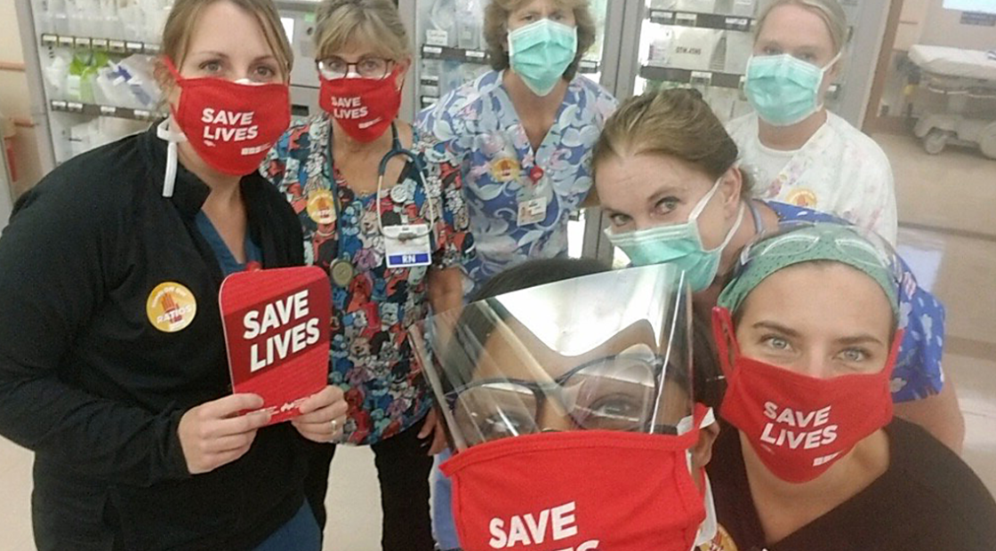 TCMC nurses holding signs and wearing masks "Save Lives"