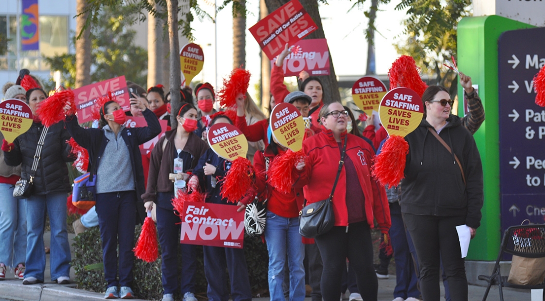 Nurses on picket line holding signs for safe staffing.
