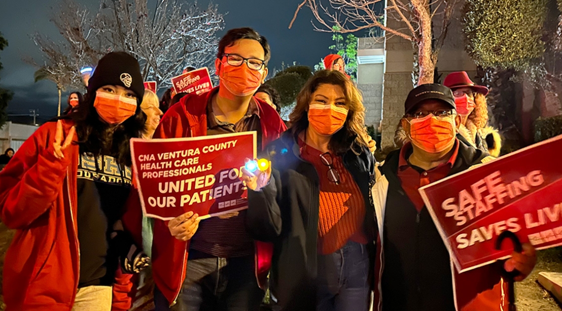 Four nurses standing outside, one holds sign "CNA Ventura County health care proffessionals united for our patients"