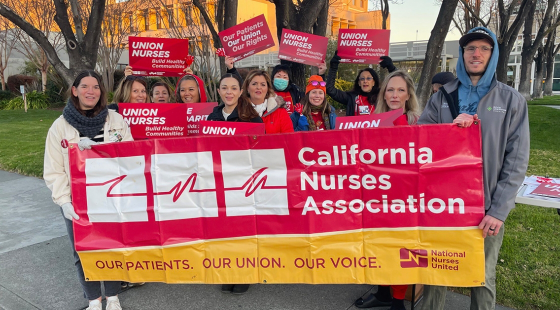 Group of 12 nurses holding banner "California Nurses Association"