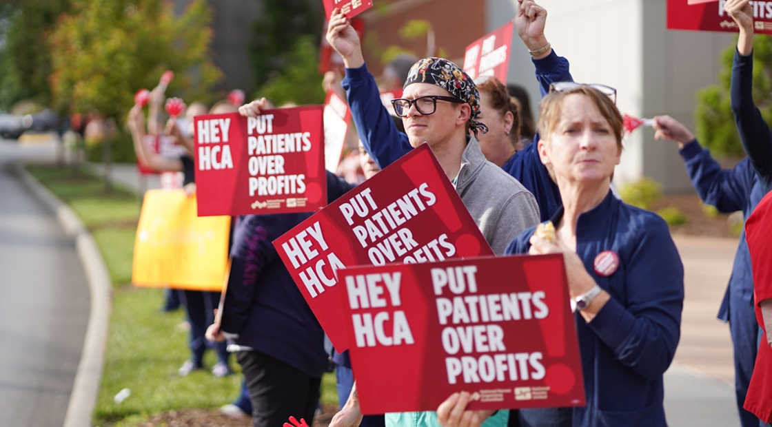 Nurses picketing outside Mission Hospital holding signs "Put Patients Over Profit"