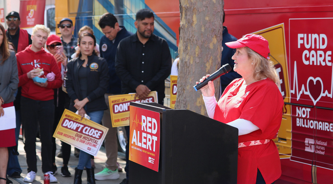 Nurse speaking at podium in front of Red Alert tour bus