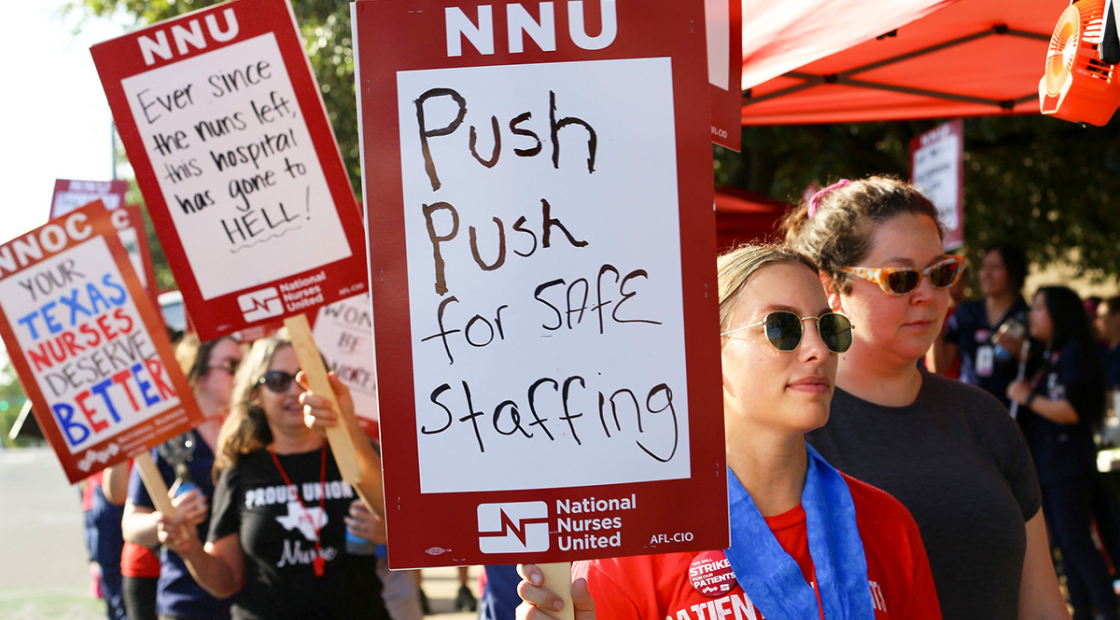 Nurse on picket line holds sign "Push Push for Safe Staffing"