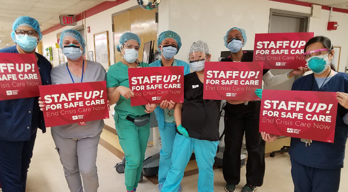 Large groups of nurses inside hospital hold signs "Staff Up for Safe Care"