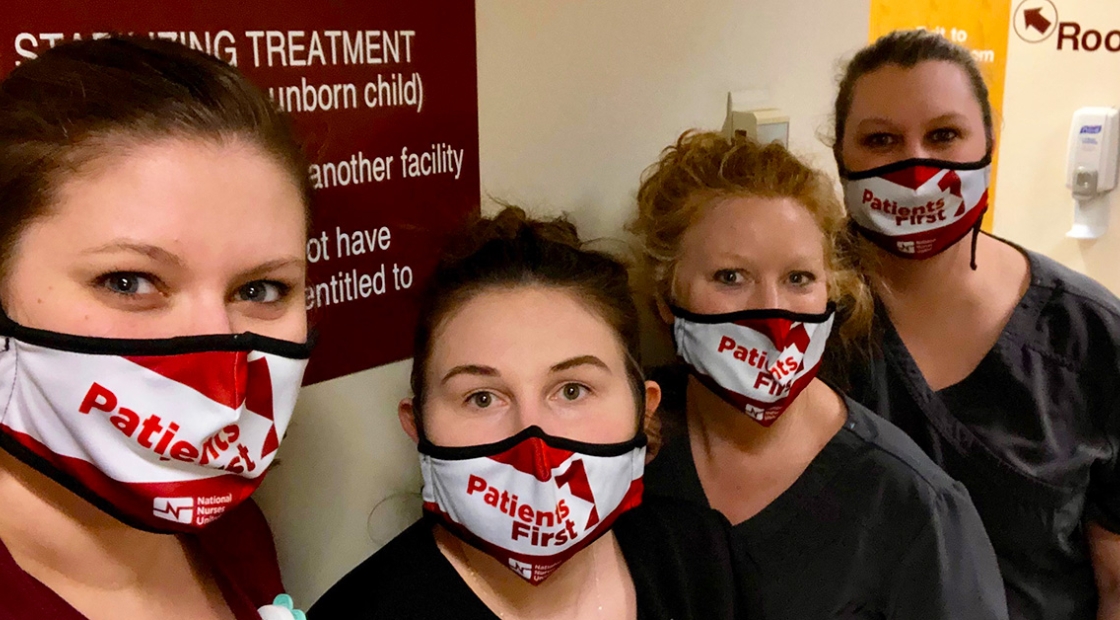 Four nurses inside hospital standing side-by-side