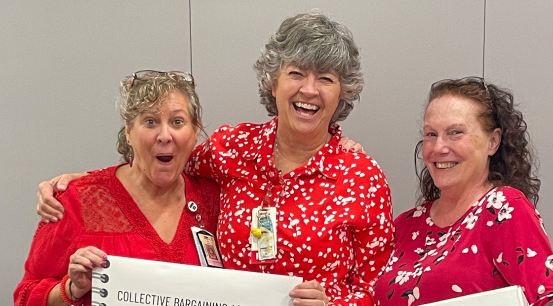 Three nurses smiling and holding ballot box