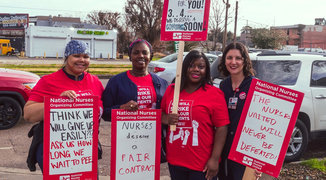 Four nurses outside holding signs "Nurses Deserve a Fair Contract" and other signs in support of UMC nurses and patients