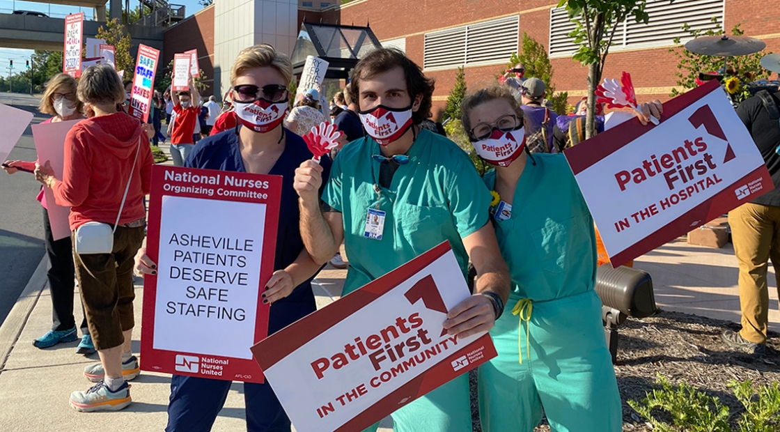 Group of three nurses outside Mission Hospital hold sign "Patients First"
