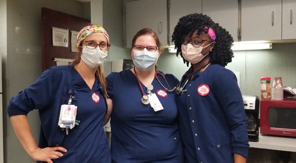 Three masked nurses inside hospital