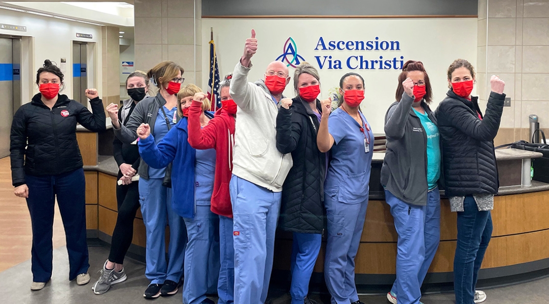 Group of nurses inside hospital giving thumbs up