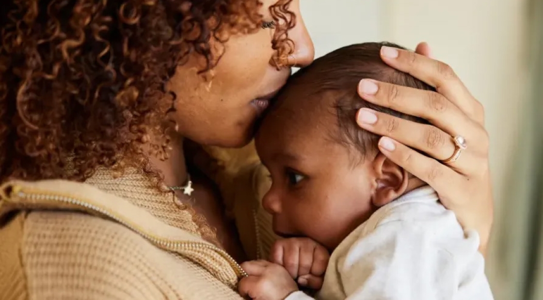 Mother holding baby on her shoulder