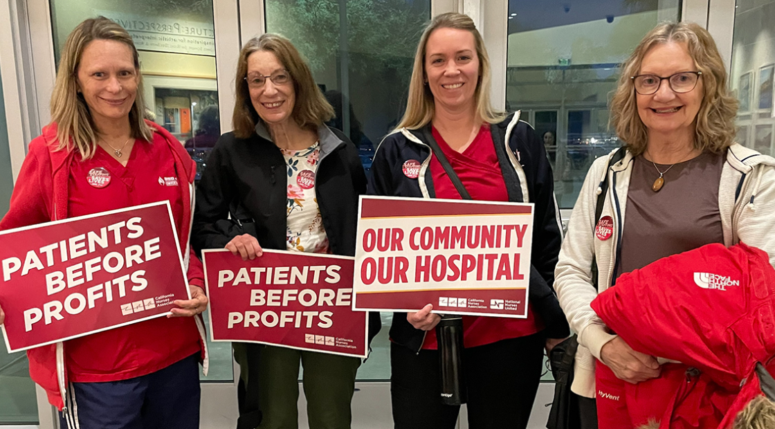 4 nurses from Desert Regional Medical Center holding signs "Patients before profits" and "Our community, our hospital"
