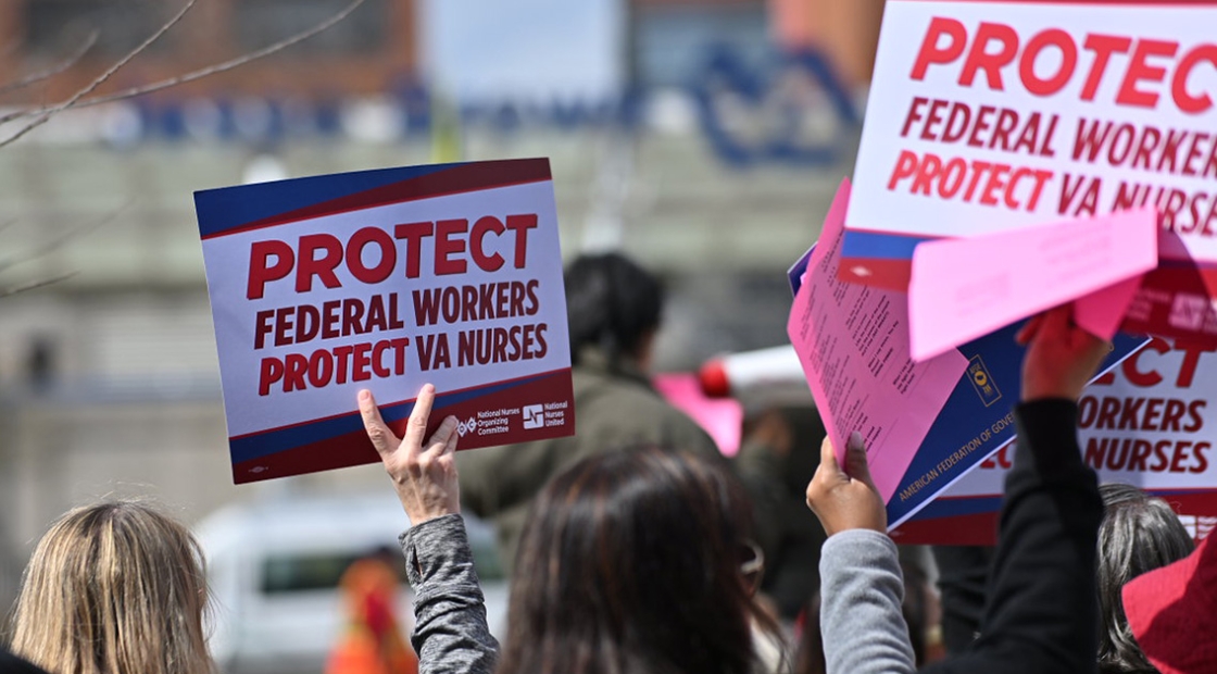 Hand holding sign "Protect Federal Workers, Protect VA Nurses"