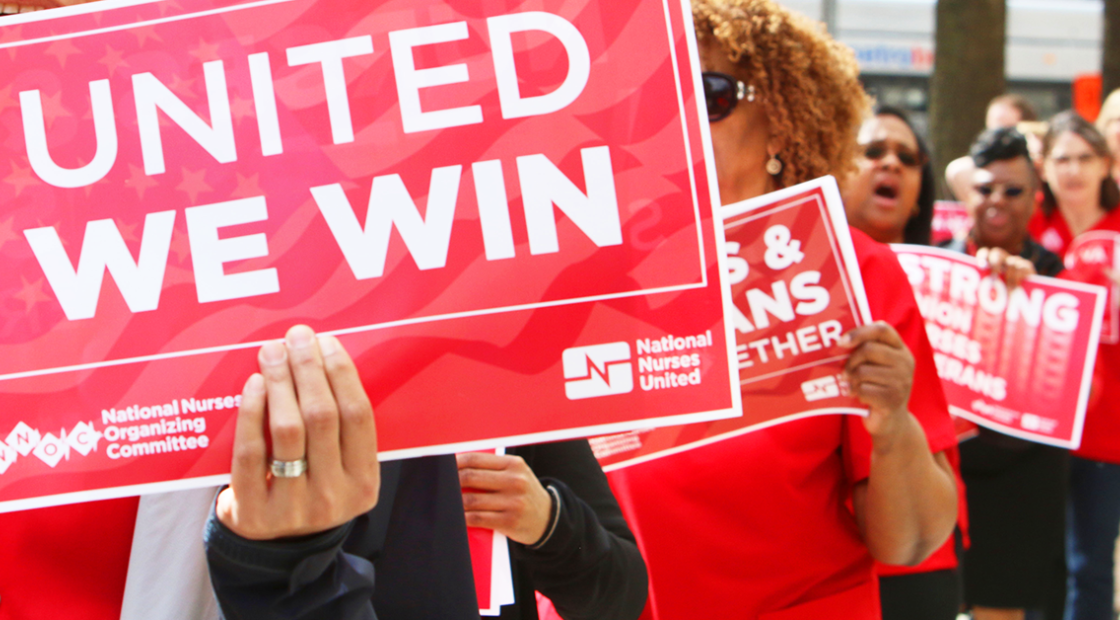 Nurses marching and holding sign "United we win"
