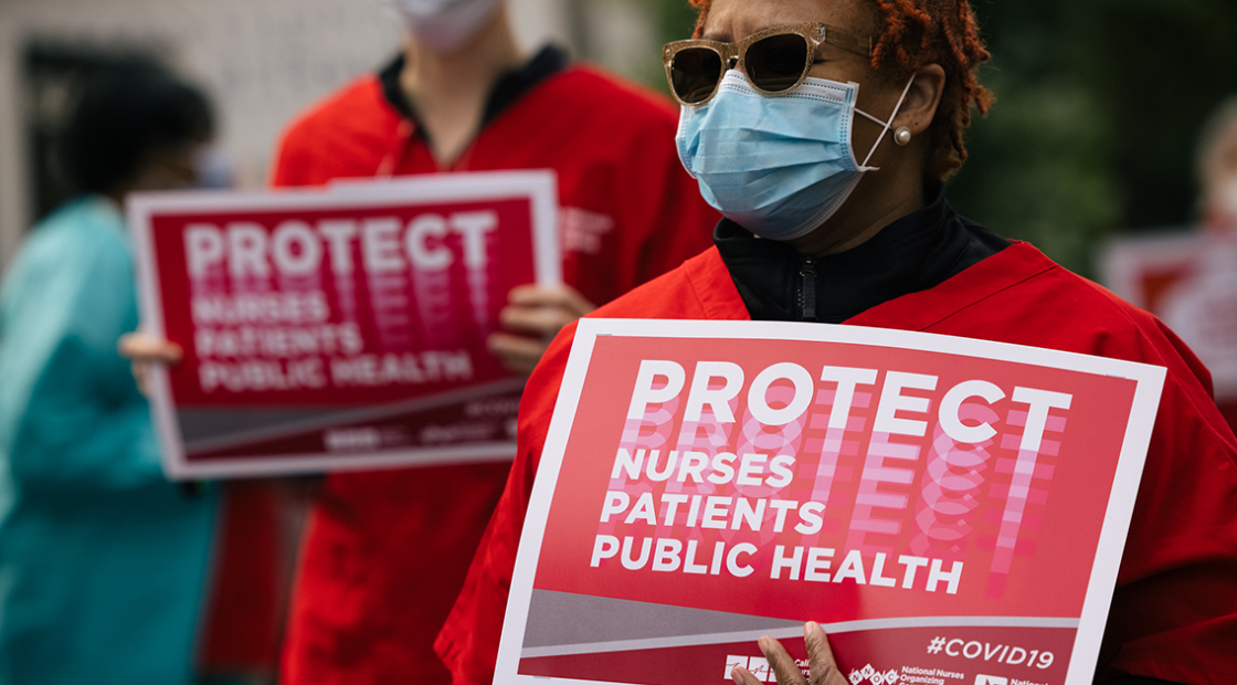 Nurses holds signs "Protect Nurses, Patients, Public Health"