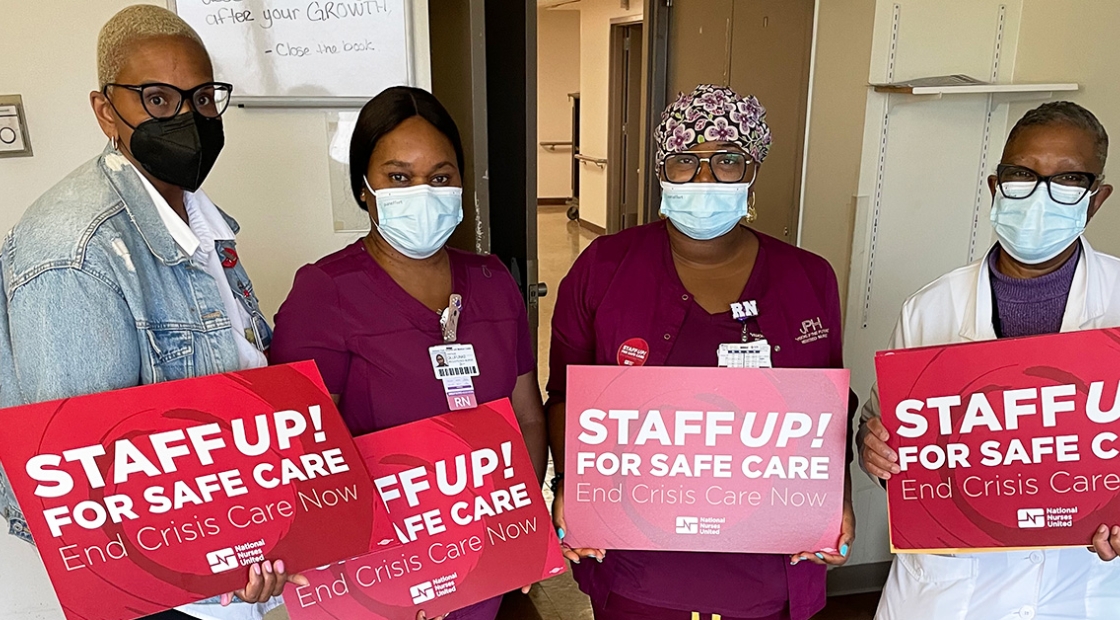 Nurses at Jackson Park Hospital hold signs that read "Staff up for safe care!"