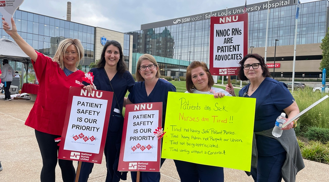 Group of five nurses outside Saint Louis University Hospital holding signs calling for patient safety