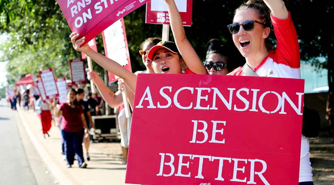 Nurse holding sign "Ascension: Be Better"