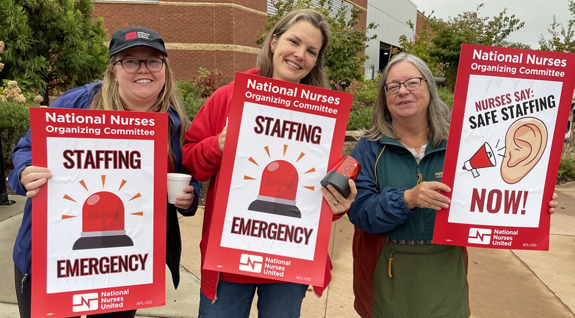 Asheville nurses hold signs that read "Staffing Emergency"