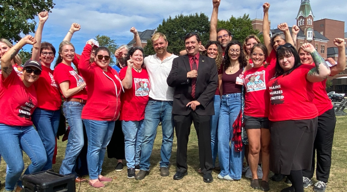 Nurses standing with Troy Jackson and Graham Platner, raised fists