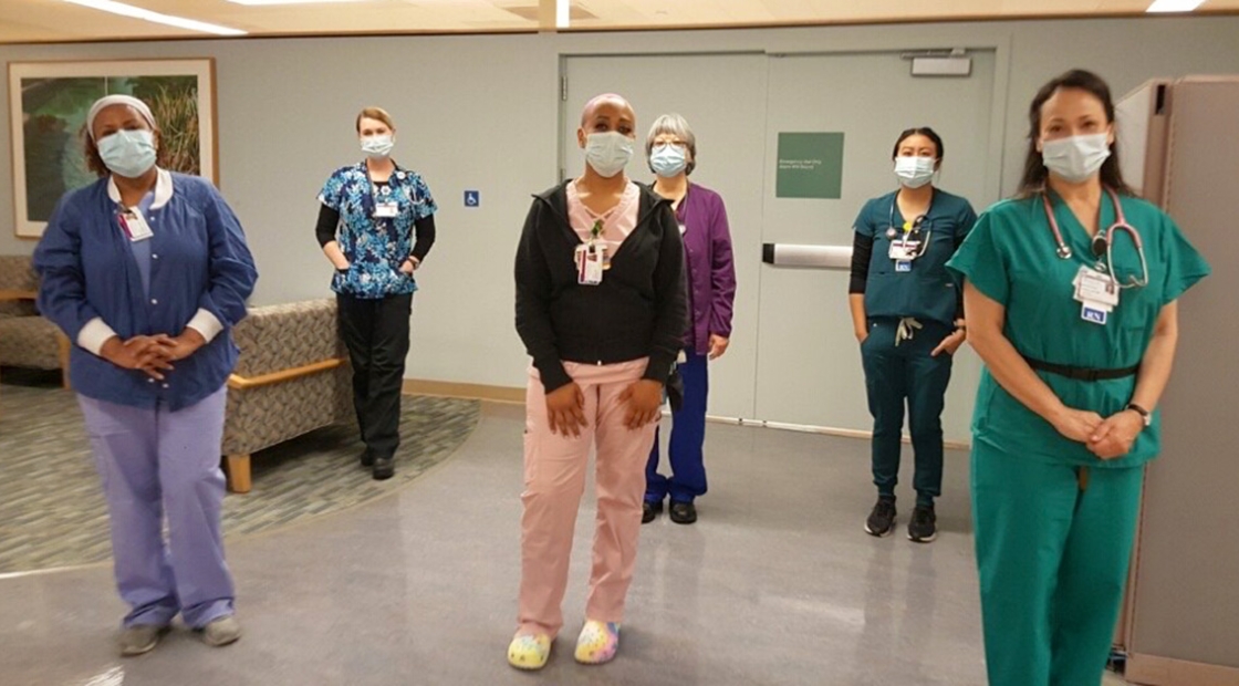 Group of six masked nurses inside hospital