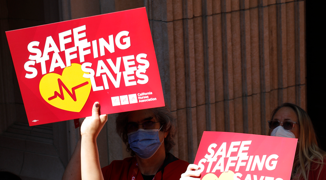 Nurses holding signs that read "Safe staffing Saves Lives"