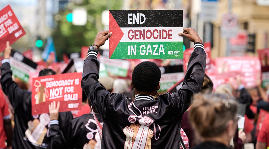 Nurse marching with sign "End Genocide in Gaza"