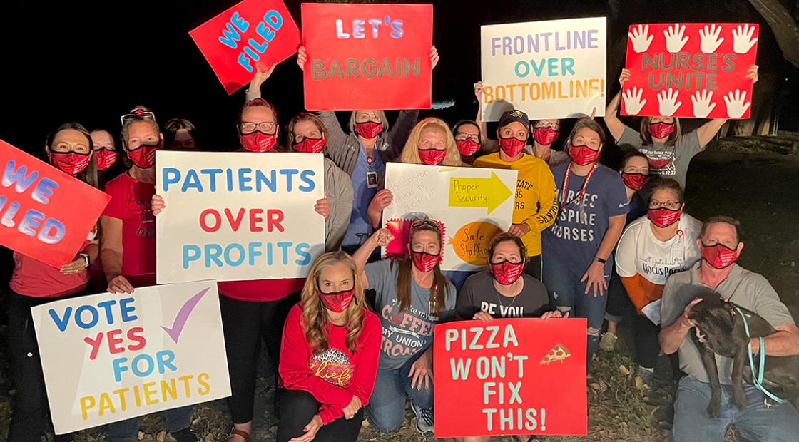 Group of nurses outside holding signs showing enthusiasm for organizing