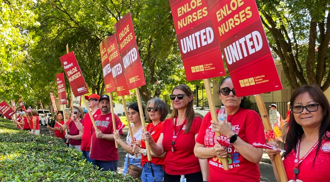 Nurses outside, holding signs "Enloe Nurses United"