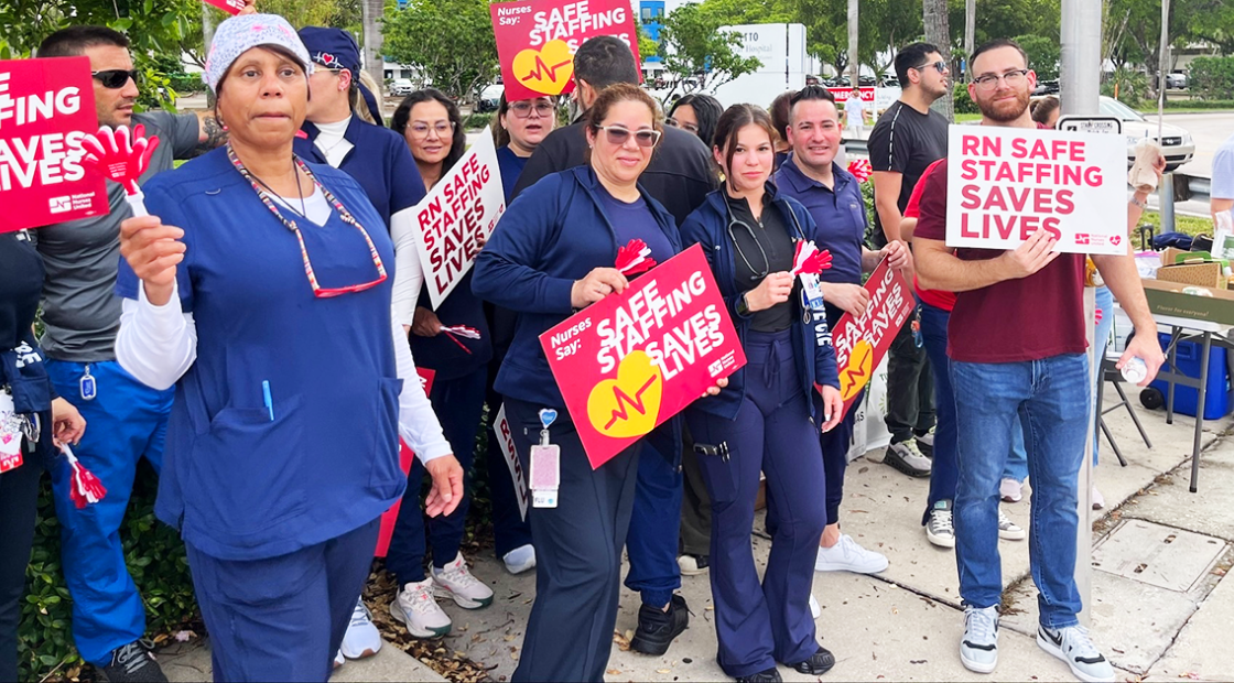 Palmetto RNs holding signs "Safe staffing saves lives" and "RN safe staffing saves lives"