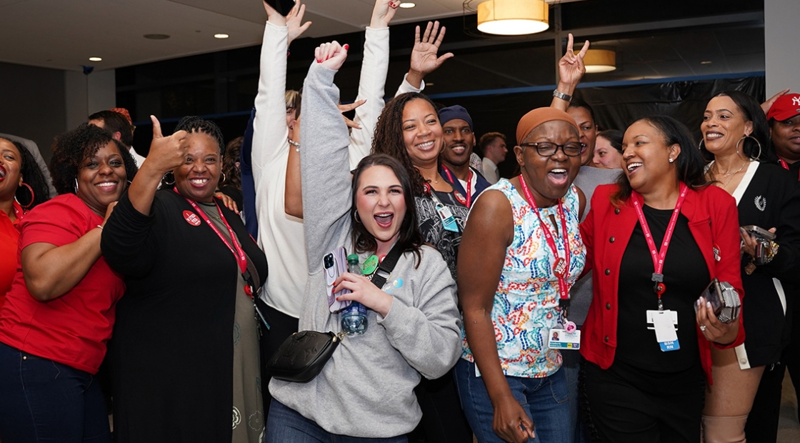 Large group of nurses celebrating with hands in the air