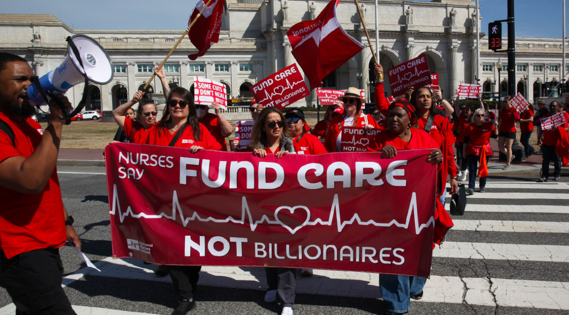 Nurses marching with banner "Fund Care NOT Billionaires"