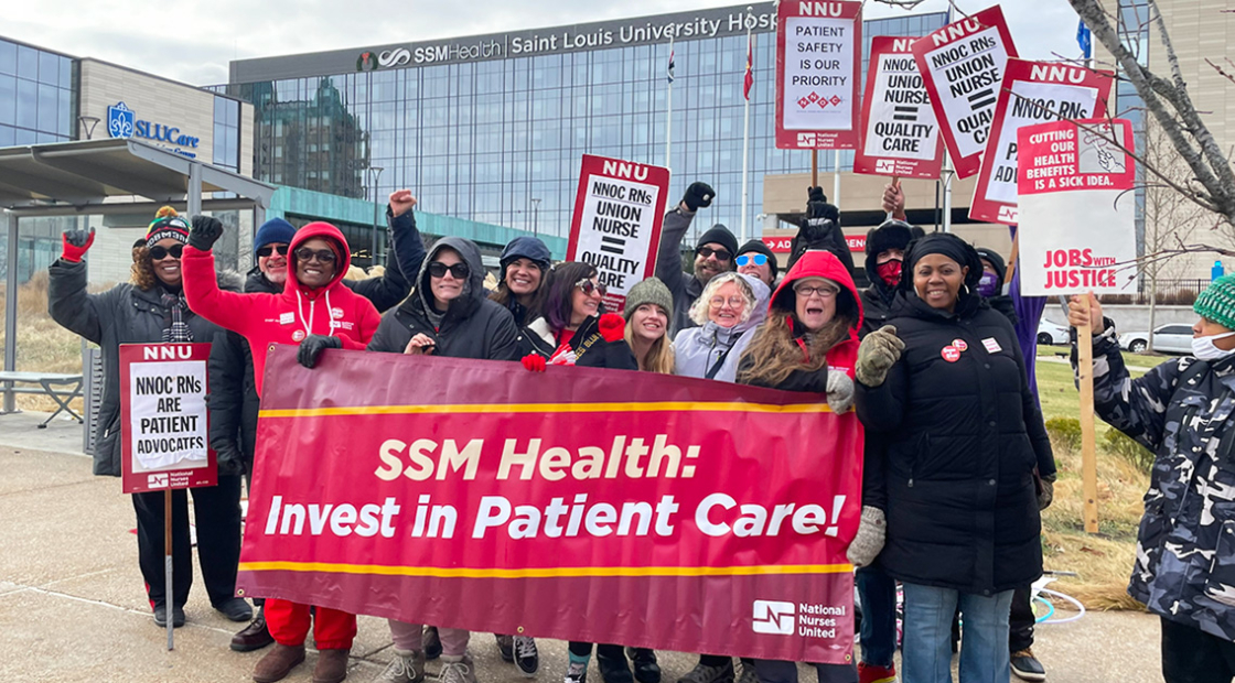 Group of nurses outside hospital, smiling, raised fists, holding banner "SSM Health: Invest in Patient Care"
