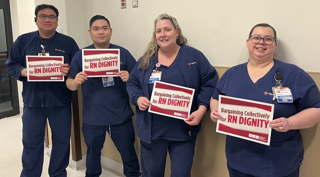 Dignity nurses holding signs that say "Nurses bargain for RN dignity."