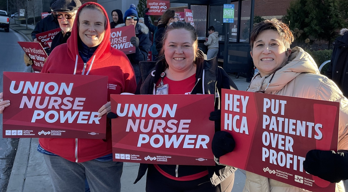 Asheville nurses hold signs that read "Union nurse power."