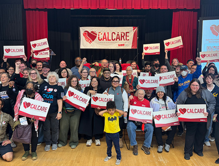 Crowd of people holding CalCare signs
