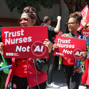 Nurses on picket line hold signs "Trust Nurses, Not A.I."