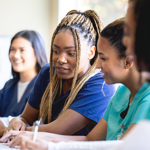 Student nurses looking at work together.