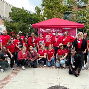 Large group of nurses posing, smiling, wearing red.