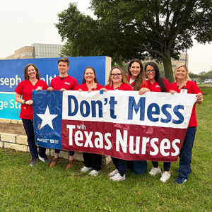 Group of nurses outside St. Joseph Health holding banner "Don't Mess With Texas Nurses"