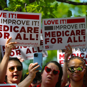 Nurses holdings signs "Love It! Improve It! Medicare for All!"