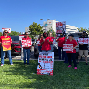 Nurses outside holding signs calling a halt of burn unit closure