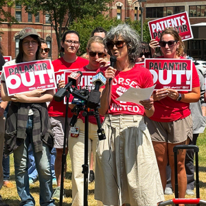 Nurses holding press conference in front of hospital, holding signs "Palantir Out!"