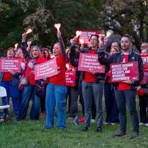 Group of nurses outside, holding lights and signs "Nurses Demand Justice for Patients and Workers Everywhere" and "Count Every Vote"